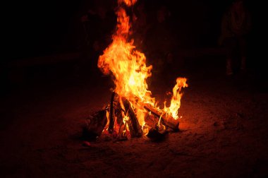 Kamp ateşinin alevleri gece yakın planda.