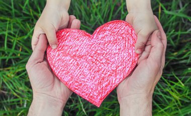 Çocuk ve babası bir kalp ellerinde. Seçici odak.