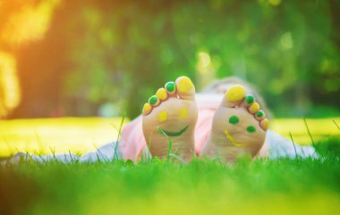 Yeşil çim üzerinde yalan çocuk. Çocuk açık havada bahar parkta eğleniyor. Seçici odak.