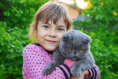 Çocuk kızla çimenlerin üzerinde bir kedi. seçici odak. 