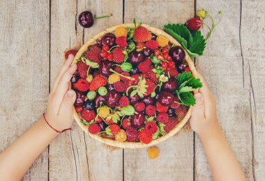 Farklı ev yapımı yaz meyveleri bir çocuğun elinde. Seçici odak. 