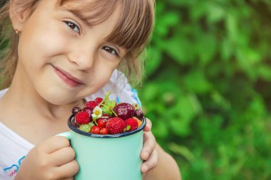 Farklı ev yapımı yaz meyveleri bir çocuğun elinde. Seçici odak.
