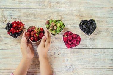 Çilek bir kalp şeklinde bir çocuğun elinde. Ev. Seçici odak.