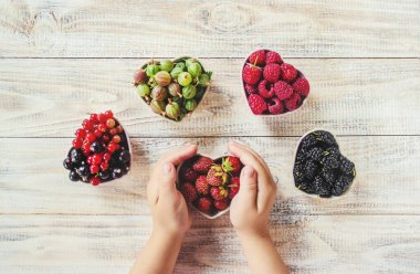 Çilek bir kalp şeklinde bir çocuğun elinde. Ev. Seçici odak.