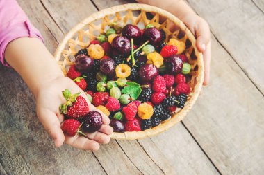 Çilek bir kalp şeklinde bir çocuğun elinde. Ev. Seçici odak.