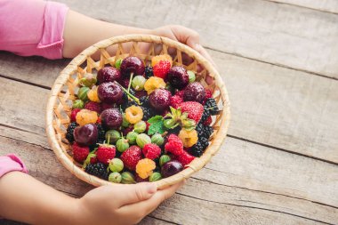 Çilek bir kalp şeklinde bir çocuğun elinde. Ev. Seçici odak.