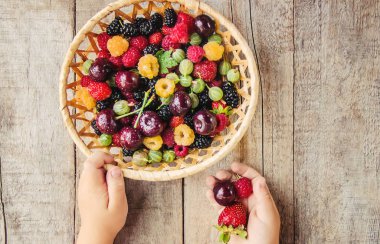 Çilek bir kalp şeklinde bir çocuğun elinde. Ev. Seçici odak.