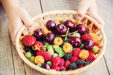 Çilek bir kalp şeklinde bir çocuğun elinde. Ev. Seçici odak.