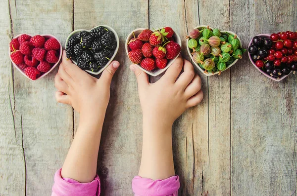 Çilek bir kalp şeklinde bir çocuğun elinde. Ev. Seçici odak.