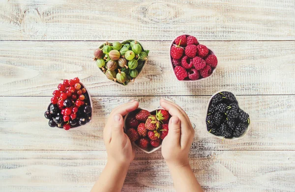 Çilek bir kalp şeklinde bir çocuğun elinde. Ev. Seçici odak.