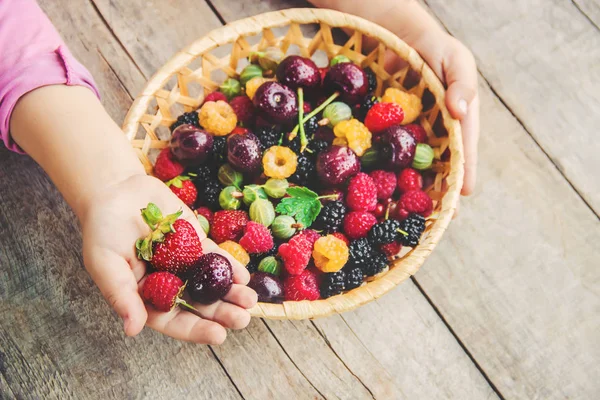 Çilek bir kalp şeklinde bir çocuğun elinde. Ev. Seçici odak.