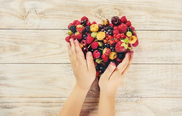 Çilek bir kalp şeklinde bir çocuğun elinde. Ev. Seçici odak.