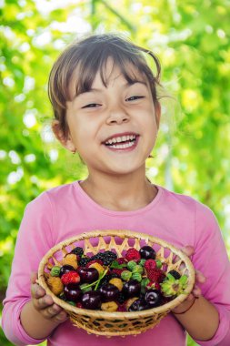 Farklı ev yapımı yaz meyveleri bir çocuğun elinde. Seçici odak.