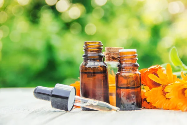 Calendula özü ve küçük bir şişe içinde çiçekler. Seçici odak. 
