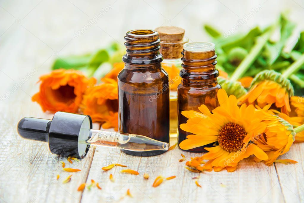 calendula extract and flowers in a small bottle. Selective focus. 