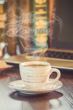 Bir fincan kahve ve bir duman Günaydın işyerinde ofiste. Seçici odak.