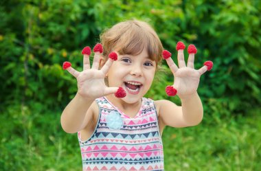 Çocuk ev yapımı ahududu yiyor. Seçici odak.