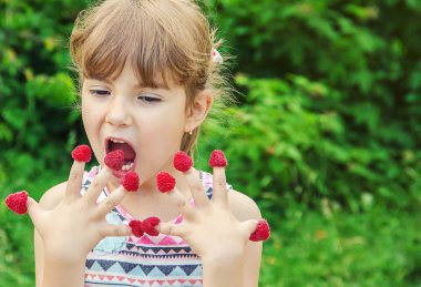 Çocuk ev yapımı ahududu yiyor. Seçici odak.