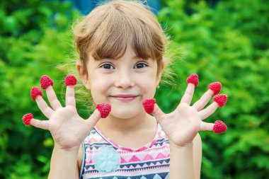 Çocuk ev yapımı ahududu yiyor. Seçici odak.