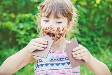 Tatlı dilli çocuk çikolata yiyor. Seçici odak. 