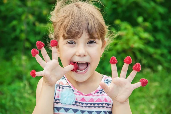 Çocuk ev yapımı ahududu yiyor. Seçici odak.