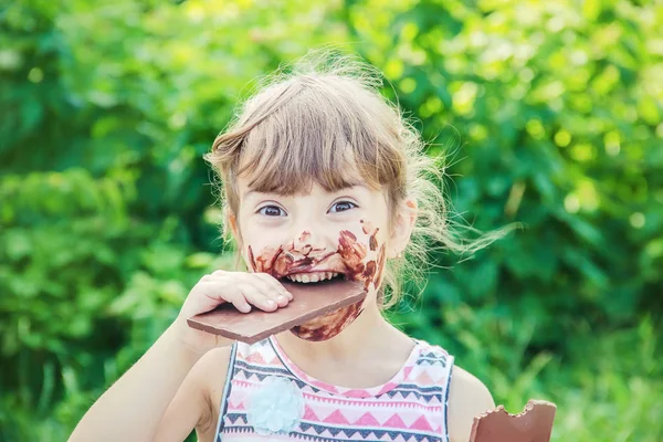 Tatlı dilli çocuk çikolata yiyor. Seçici odak. 