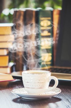 Bir fincan kahve ve bir duman Günaydın işyerinde ofiste. Seçici odak.