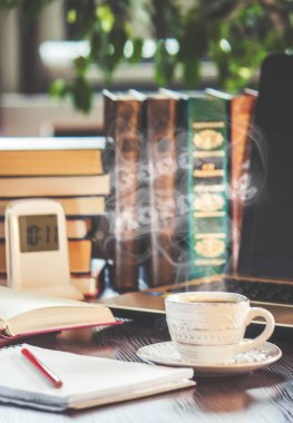 Bir fincan kahve ve bir duman Günaydın işyerinde ofiste. Seçici odak.