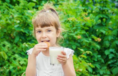 Çocuk süt ve kurabiye içer. Seçici odak.
