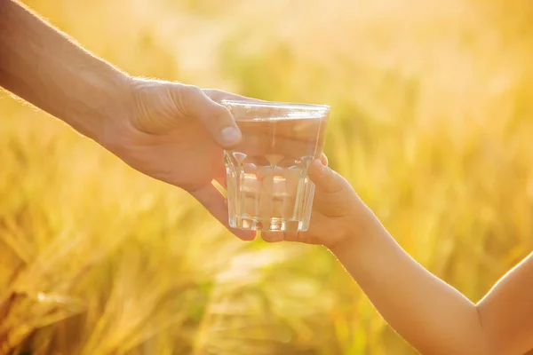 De vader geeft het kind een glas water. Selectieve aandacht. — Stockfoto