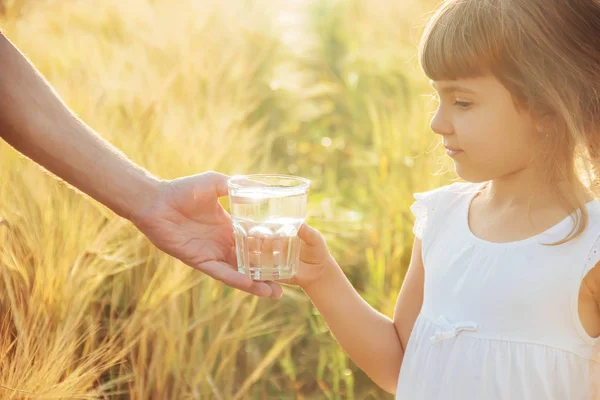 父亲给孩子一杯水。选择性的焦点. — 图库照片