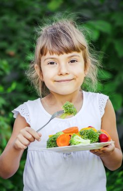 Çocuk sebze yiyor. Yaz fotoğrafı. Seçici odaklanma doğası