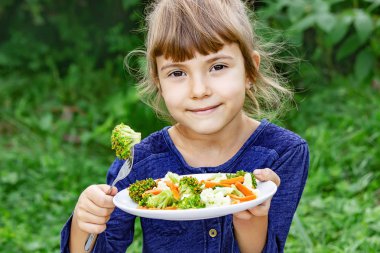 Çocuk sebze yiyor. Yaz fotoğrafı. Seçici odaklanma doğası
