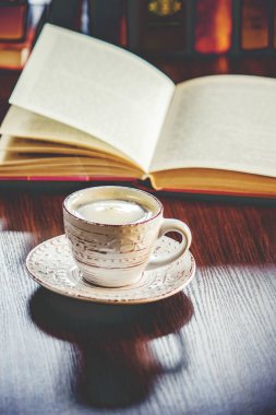 Kahve sabah işyerinde. bir kitap ya da dizüstü bilgisayar ile. seçici odak. içki.
