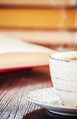 Kahve sabah işyerinde. bir kitap ya da dizüstü bilgisayar ile. seçici odak. içki.