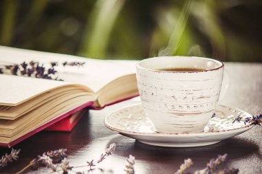 Kahve sabah işyerinde. bir kitap ya da dizüstü bilgisayar ile. seçici odak. içki.