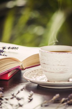 Kahve sabah işyerinde. bir kitap ya da dizüstü bilgisayar ile. seçici odak. içki.