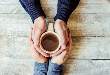 Aşıkların elinde kahvaltı için bir bardak içki. Seçici odaklanma. Doğa.