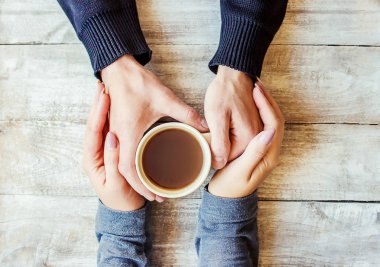 Aşıkların elinde kahvaltı için bir bardak içki. Seçici odaklanma. Doğa.