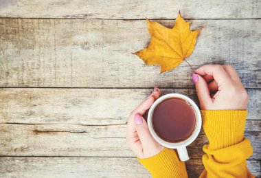 Bir fincan çay ve sıcak bir sonbahar arka plan. Seçici odak. içki.