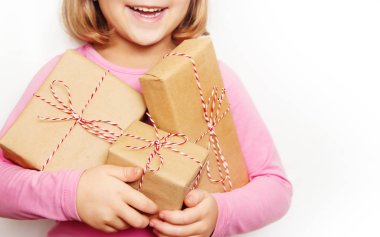 Çocuk bir Noel dekor ve hediyeler beyaz bir arka plan üzerinde tutar. Seçici odak. Mutlu.