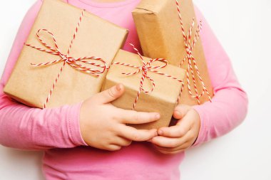 Çocuk bir Noel dekor ve hediyeler beyaz bir arka plan üzerinde tutar. Seçici odak. Mutlu.