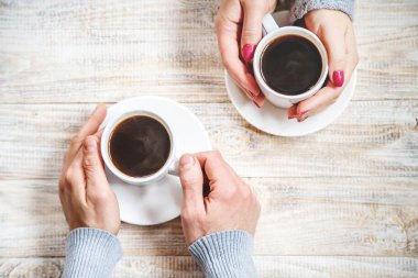 Aşıkların elinde kahvaltı için bir bardak içki. Seçici odaklanma. Doğa.