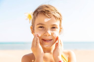 Sahildeki çocuk güneş kremi sürüyor. Seçici odaklanma. İnsanlar.