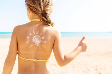 Sahildeki çocuk güneş kremi sürüyor. Seçici odaklanma. İnsanlar.