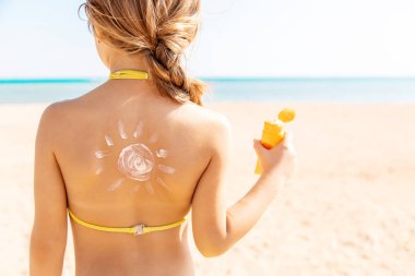 Sahildeki çocuk güneş kremi sürüyor. Seçici odaklanma. İnsanlar.