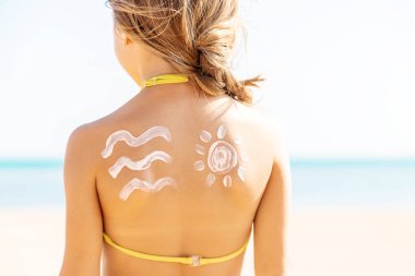 Sahildeki çocuk güneş kremi sürüyor. Seçici odaklanma. İnsanlar.