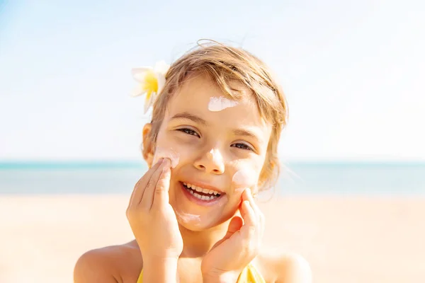 Sahildeki çocuk güneş kremi sürüyor. Seçici odaklanma. İnsanlar.