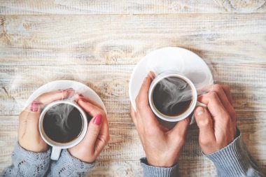 Aşıkların elinde kahvaltı için bir bardak içki. Seçici odaklanma. Doğa.