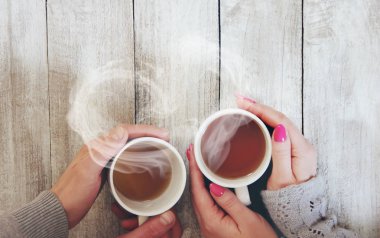 Bir fincan çay bir erkek ve bir kadın elinde. Seçici odak. şirin.